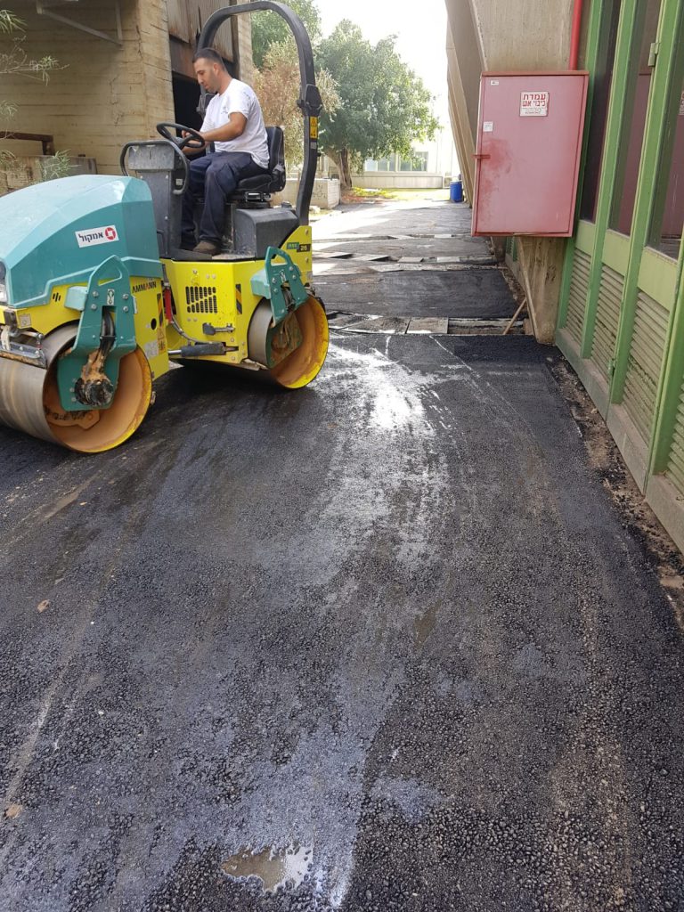 מחפרון מפנה פסולת בניין באתר עבודה