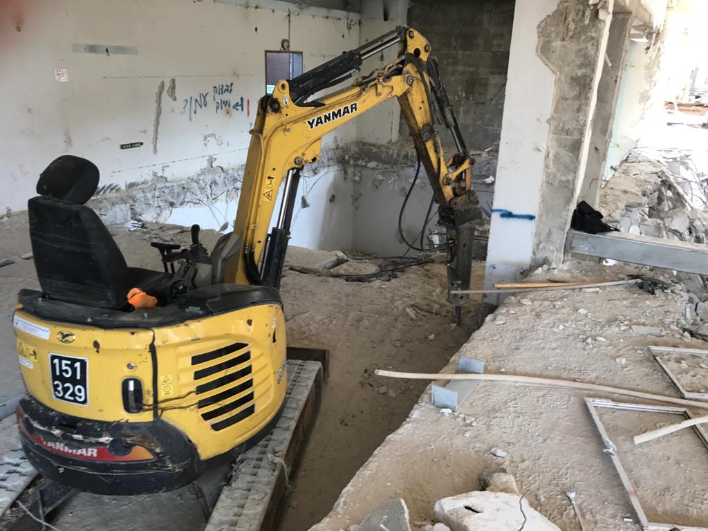 עבודת מחפרון בפינוי פסולת